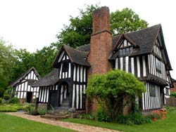 external view of this characteristic black and white timber framed building and its distinctive brick chimney